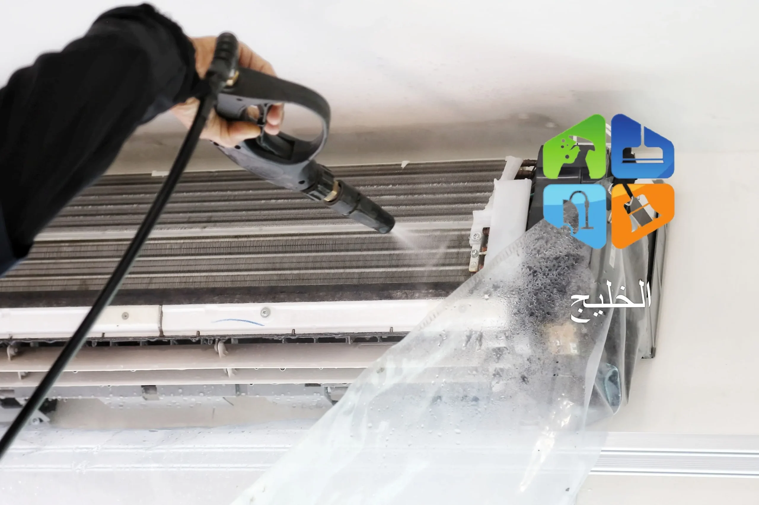 a person holding a hose and spraying water on a plastic surface